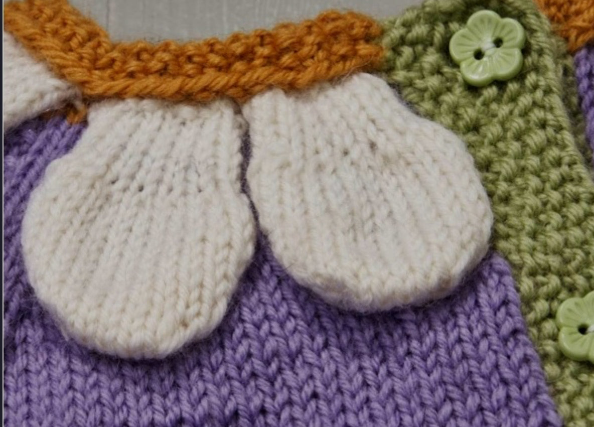 Blooming petals cardigan is a floral style baby cardigan. knitted applique leaves and petals adorn the front of the cardigan. Seamless construction from the top down, making this a simple and quick baby cardigan. knitting pattern jane burns