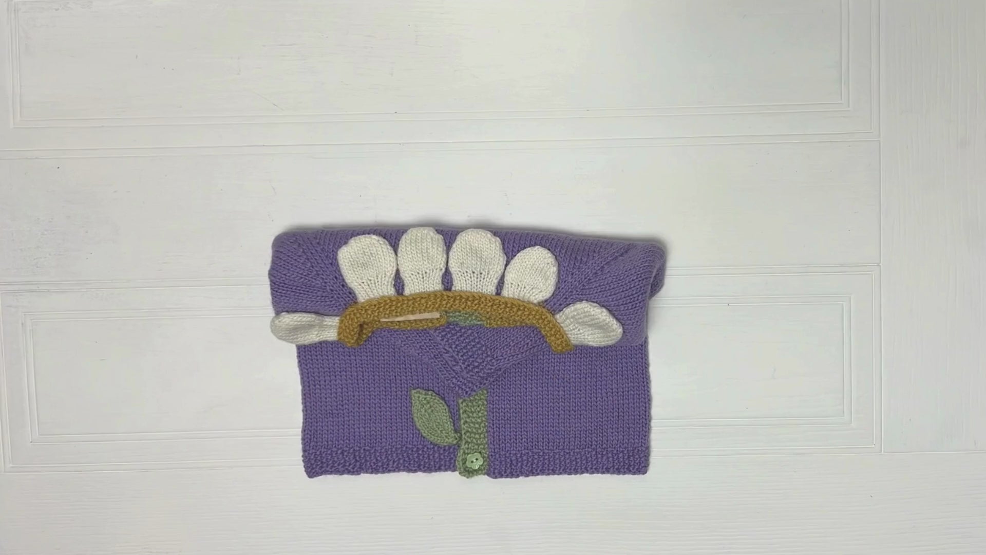 Blooming petals cardigan is a floral style baby cardigan. knitted applique leaves and petals adorn the front of the cardigan. Seamless construction from the top down, making this a simple and quick baby cardigan. knitting pattern jane burns