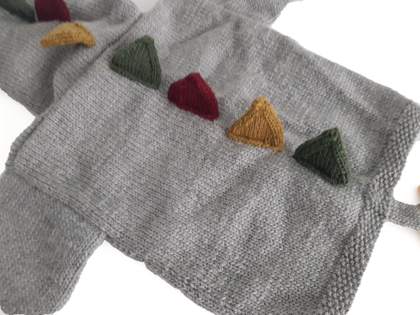 dinosaur hooded cardigan dino hoodie baby knitting pattern with spikes and tail, jane burns. Simple hooded cardigan with spikes and tail to bring the dinosaur roaring to life.