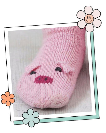 Close up of a knitted pig sock toe showing two pink ears, dark pink snout and embroidered eyes