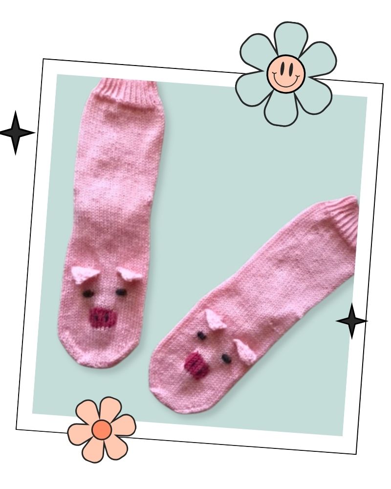 Pair of pink hand knitted pig socks laid flat, top down sock knitting pattern in child, teen and adult sizes