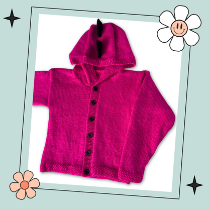 Pink knitted hoodie with cartoon face design on the back and black spikes on the hood, knitting pattern for kids hooded cardigan jane burns