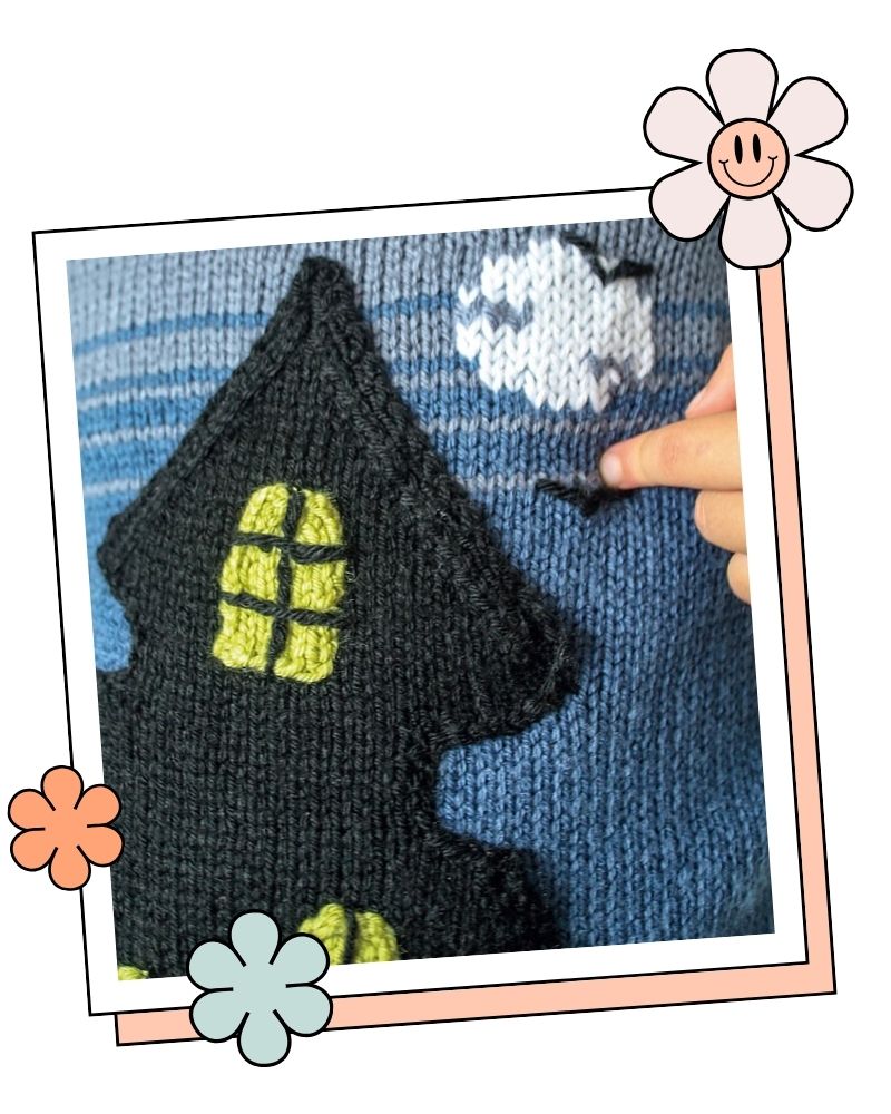 Close up of the black knitted house pocket with lime green windows, moon and bat, no intarsia