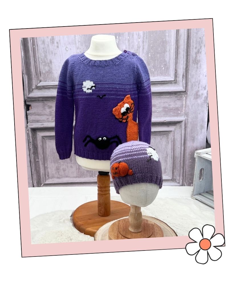 Mix and Match halloween hats knitting pattern collection by Jane Burns.
A purple knit sweater and matching beanie displayed on mannequin heads, featuring a spider, cat, and moon motif. The photo is framed with a pink border and a flower graphic in the corner.