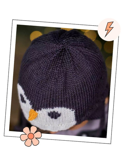 Crown of a knitted penguin hat showing the shaping and penguin face, aviator hat knitting pattern