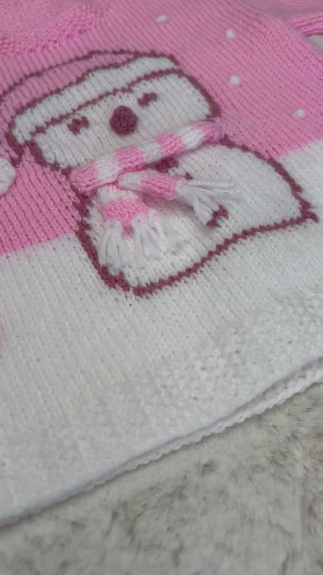Girls pink Christmas jumper knitting pattern with an intarsia snowman in a bobble hat and stripy scarf, sizes 2 to 11