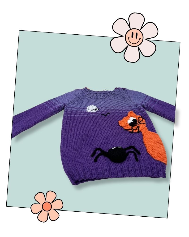 Scaredy Cat kids Halloween jumper knitting pattern, purple jumper with an orange cat and black spider, laid flat