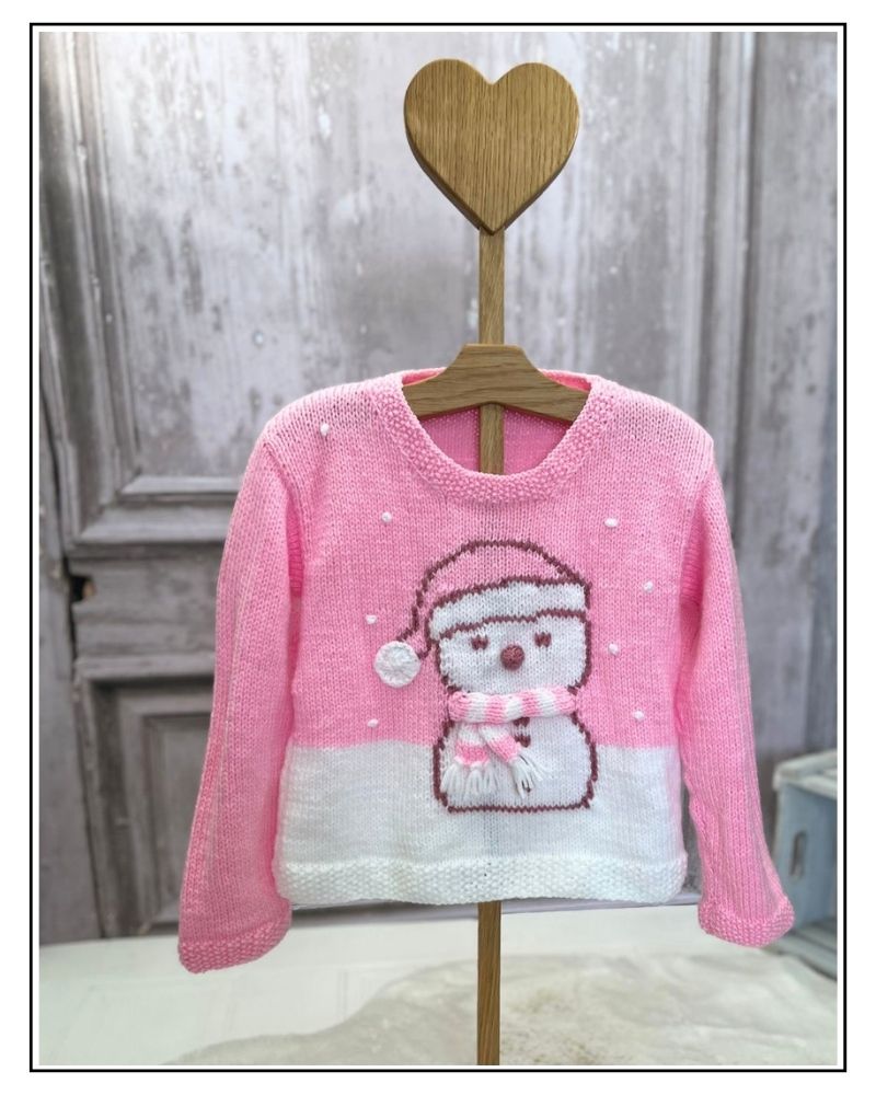 Pink snowman jumper knitting pattern for girls, Snolene the snowman jumper on a wooden heart hanger