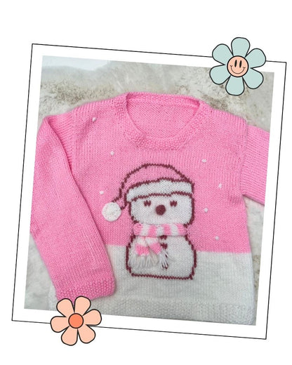 Close up of the snowman motif with sleepy eyes, a knitted 3D nose, pink and white stripy scarf with fringe and hat bobble