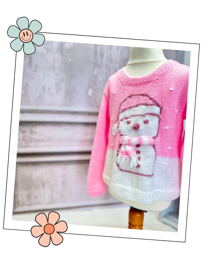 Pink snowman jumper for girls on a dress form, DK knitting pattern with a charted snowman and 3D details