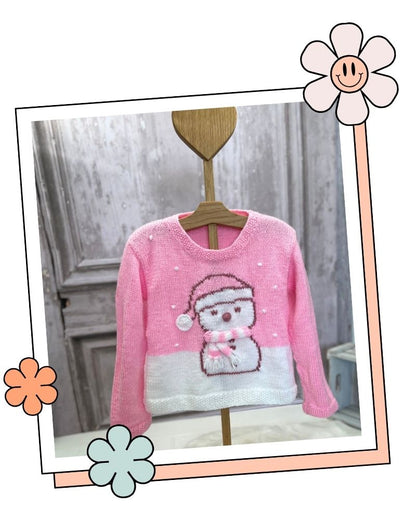 Pastel pink snowman Christmas jumper on a hanger, knitted flat and seamed in DK yarn, knitting pattern for girls