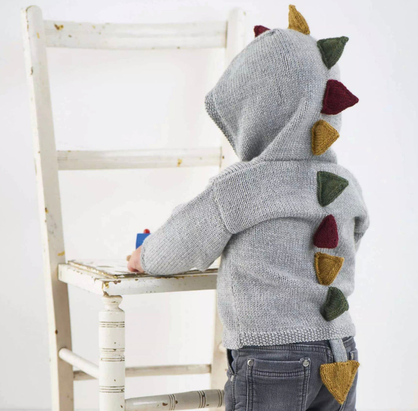 dinosaur hooded cardigan dino hoodie baby knitting pattern with spikes and tail, jane burns. Simple hooded cardigan with spikes and tail to bring the dinosaur roaring to life.