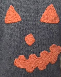 knitting pattern for kids jumper, childs halloween sweater with pumpkin eyes, nose and mouth on the front. Easy kids jumper knitting pattern by jane burns